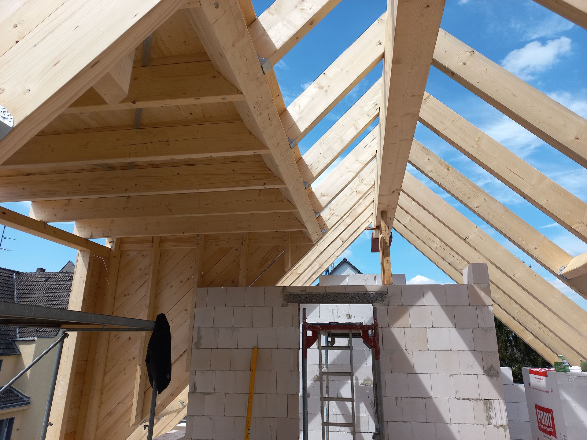 Das Dach eines Hauses wird mit Holzbalken gebaut