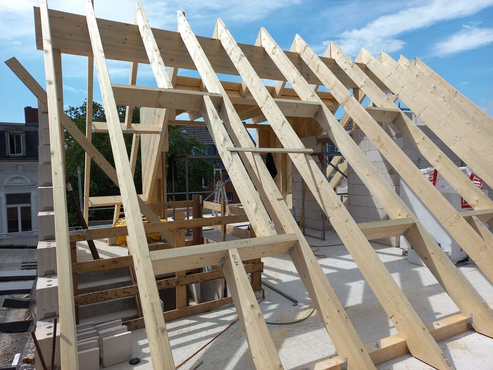 Auf einem Gebäude wird eine Holzkonstruktion errichtet