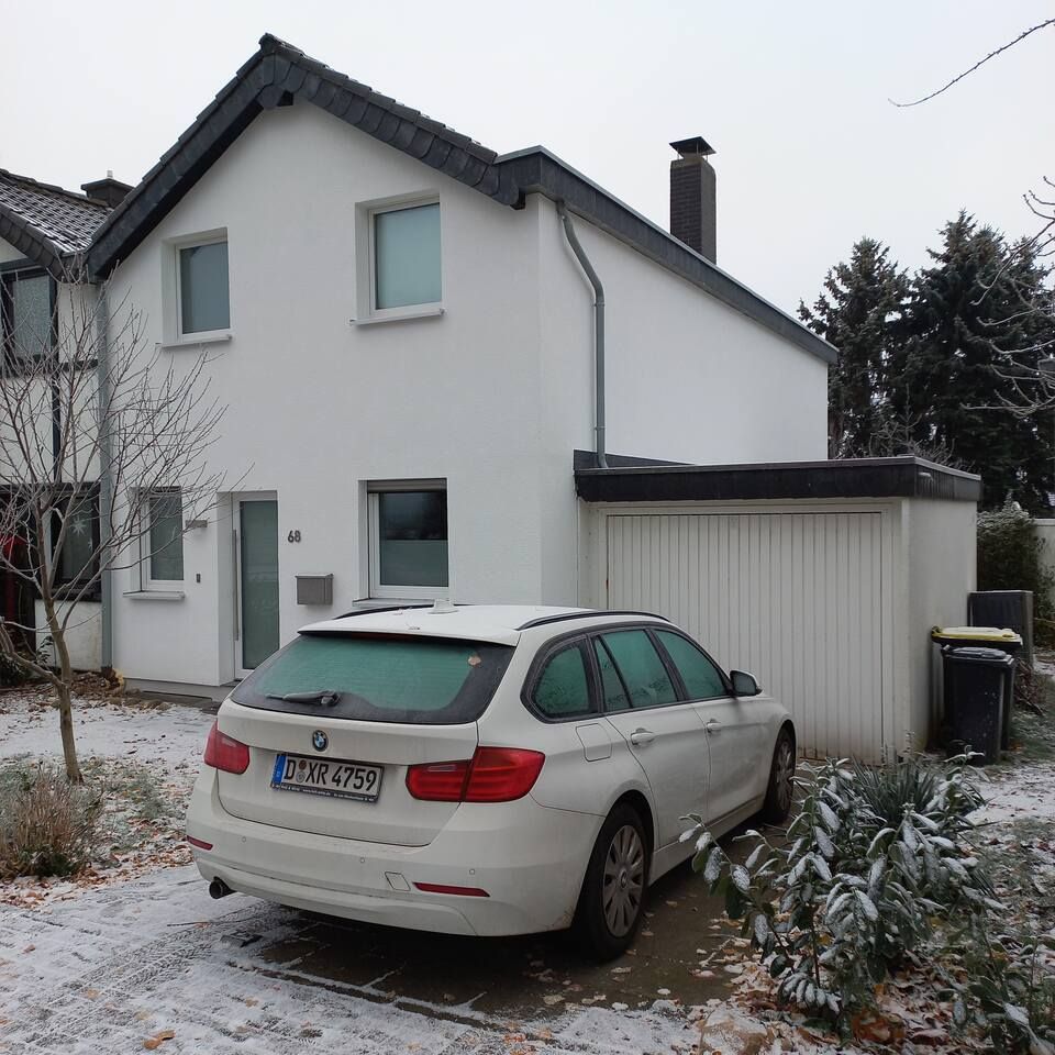 Ein weißer BMW steht vor einem weißen Haus