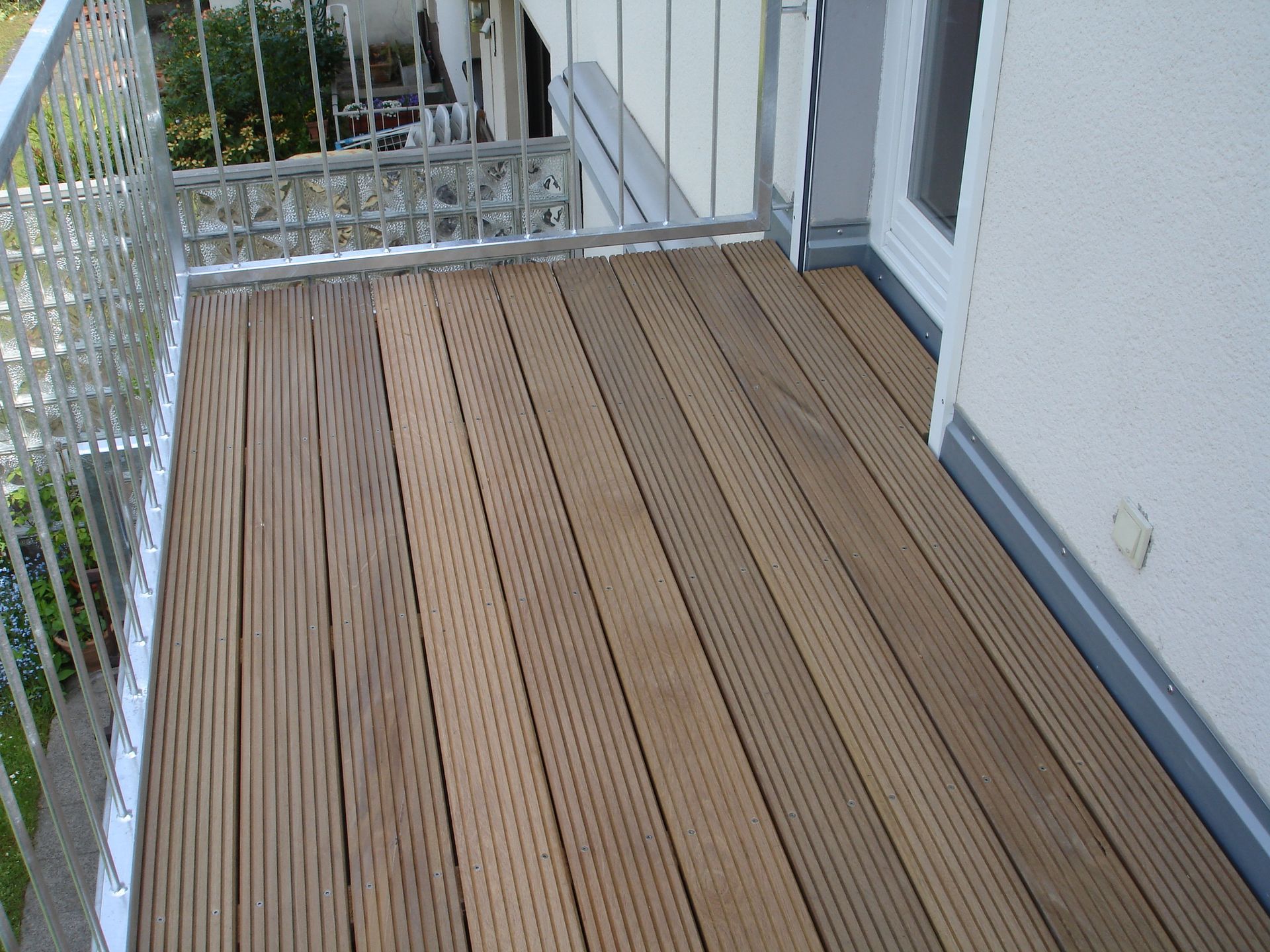 Ein Balkon mit Holzdeck und Metallgeländer