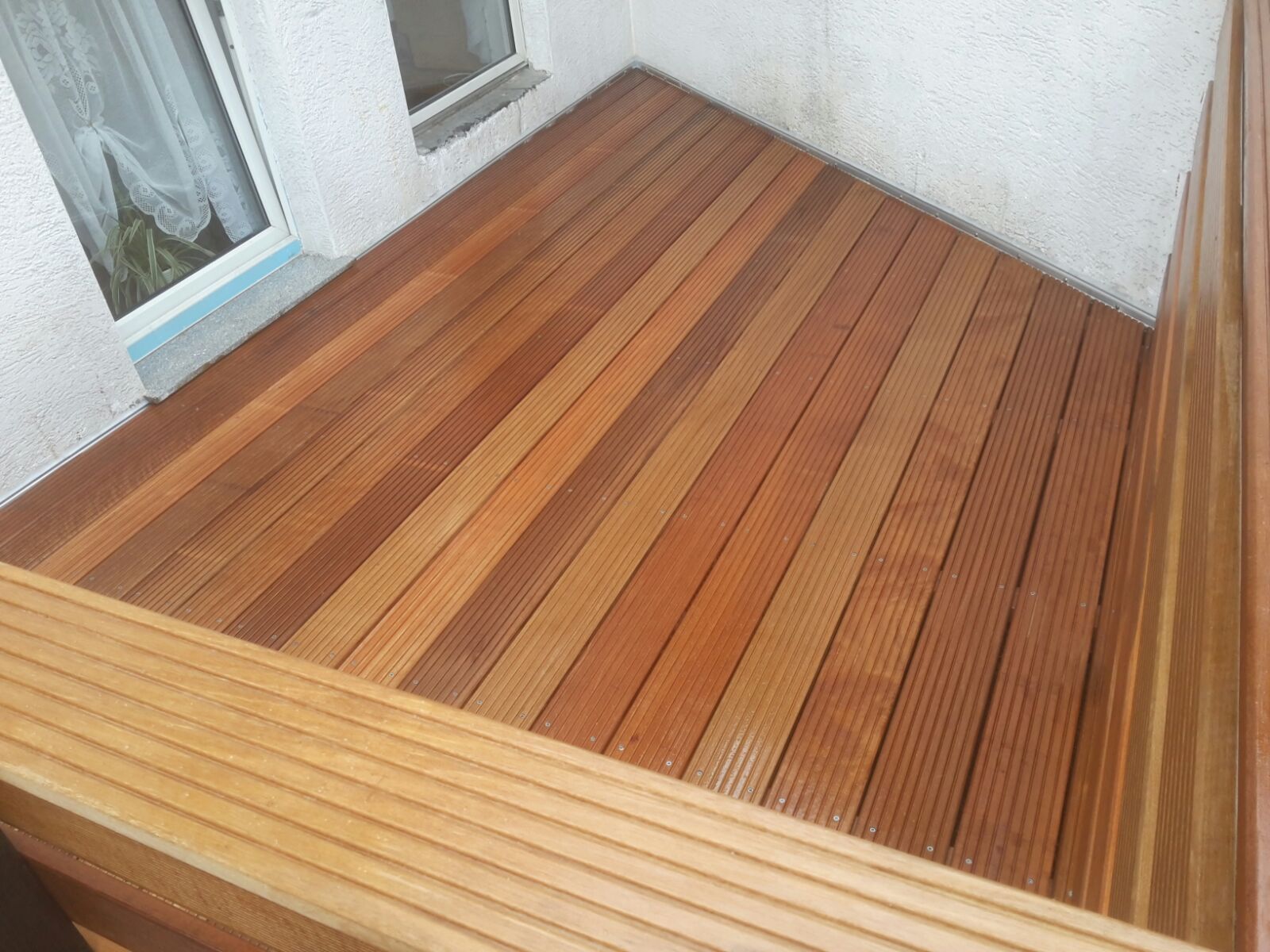 Eine Luftaufnahme eines Holzdecks mit einem Fenster im Hintergrund.