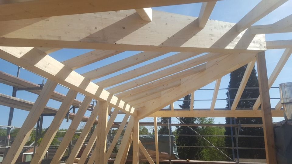 Das Dach eines Gebäudes wird mit Holzbalken gebaut.