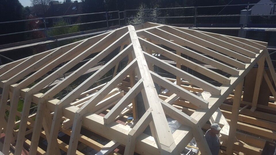 Auf einem Gebäude wird eine Holzkonstruktion errichtet.