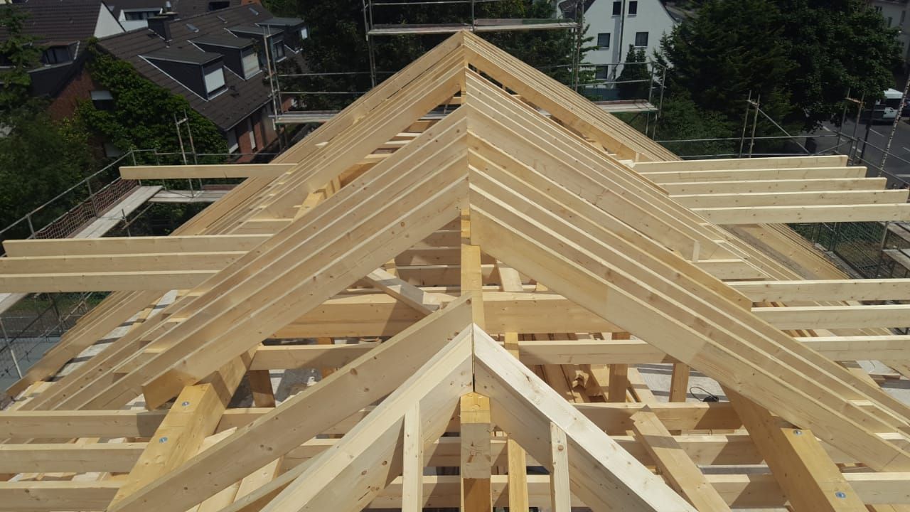 Das Dach eines Gebäudes wird mit Holzbalken gebaut.