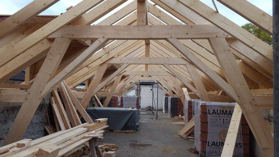 Das Dach eines Gebäudes wird mit Holzbalken gebaut.