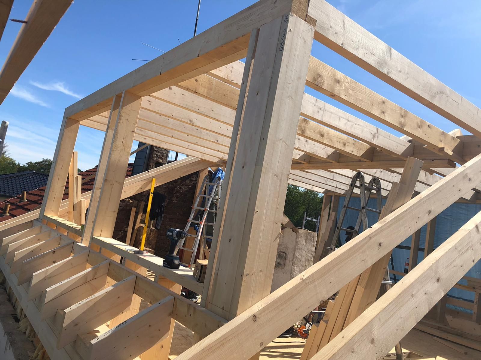 Es wird eine Holzkonstruktion errichtet, im Hintergrund ist eine Leiter zu sehen.