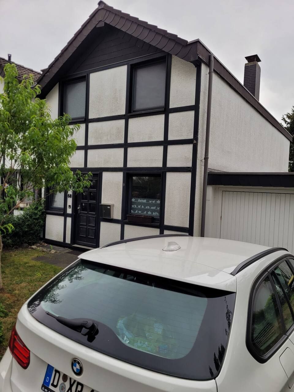 Ein weißer BMW steht vor einem Haus