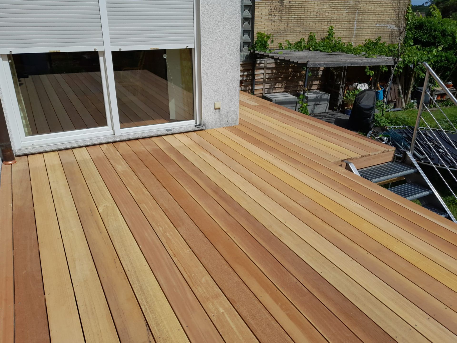 Ein Holzdeck mit Glasschiebetür und Treppe