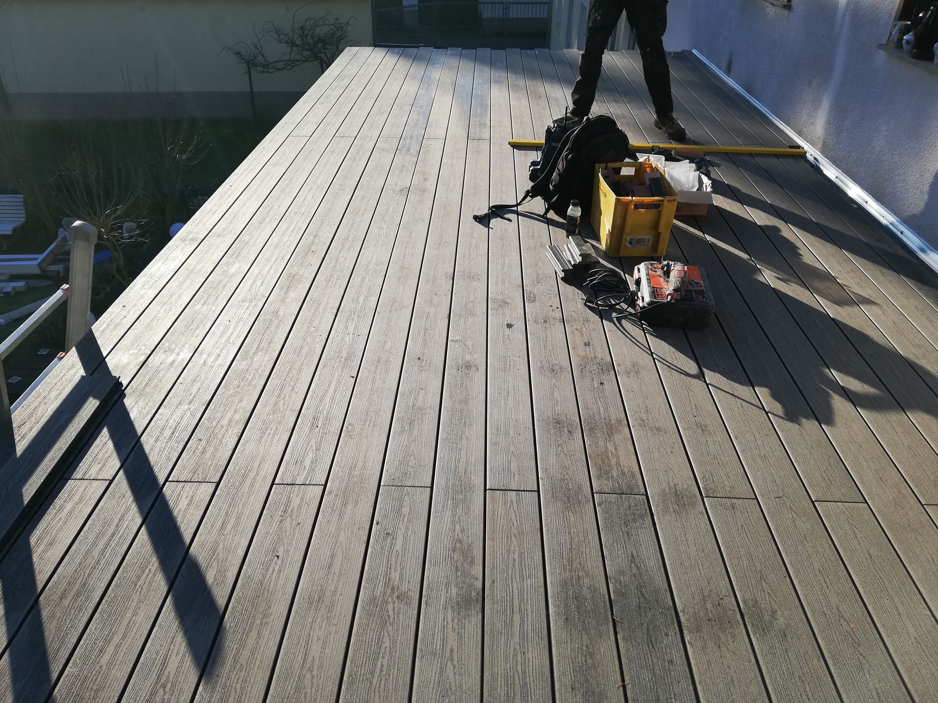 Eine Person steht auf einem Holzdeck mit einer gelben Kiste darauf
