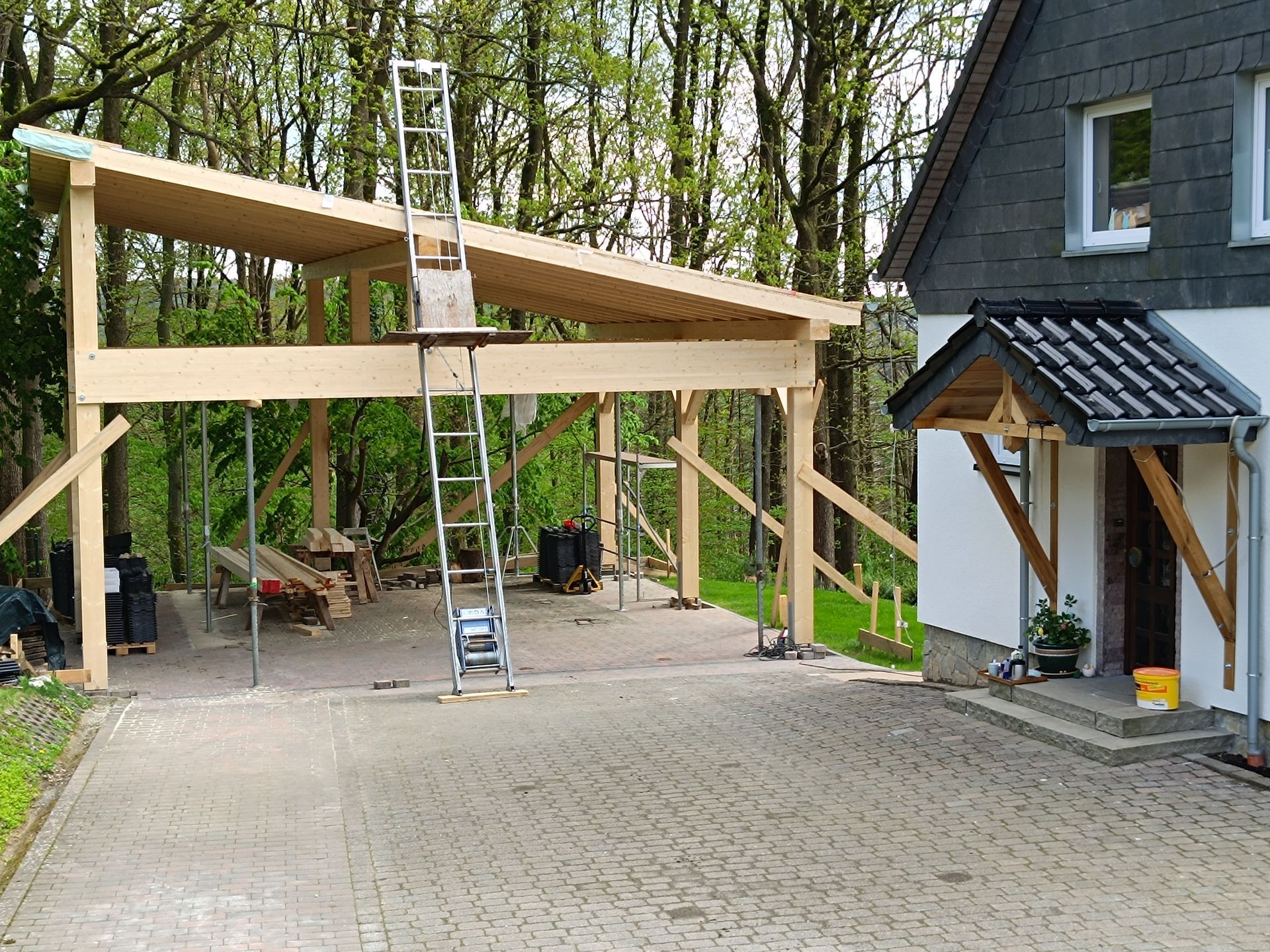 Vor einem Haus wird ein Carport gebaut.