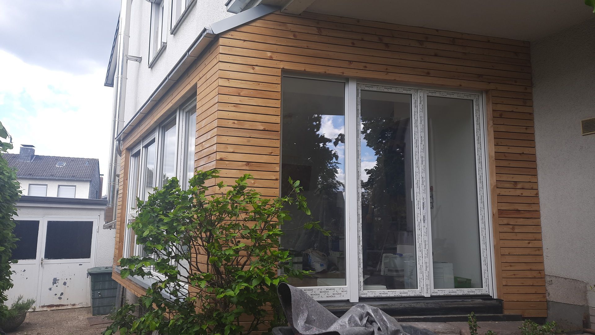 Ein Haus mit vielen Fenstern und einer Backsteinmauer