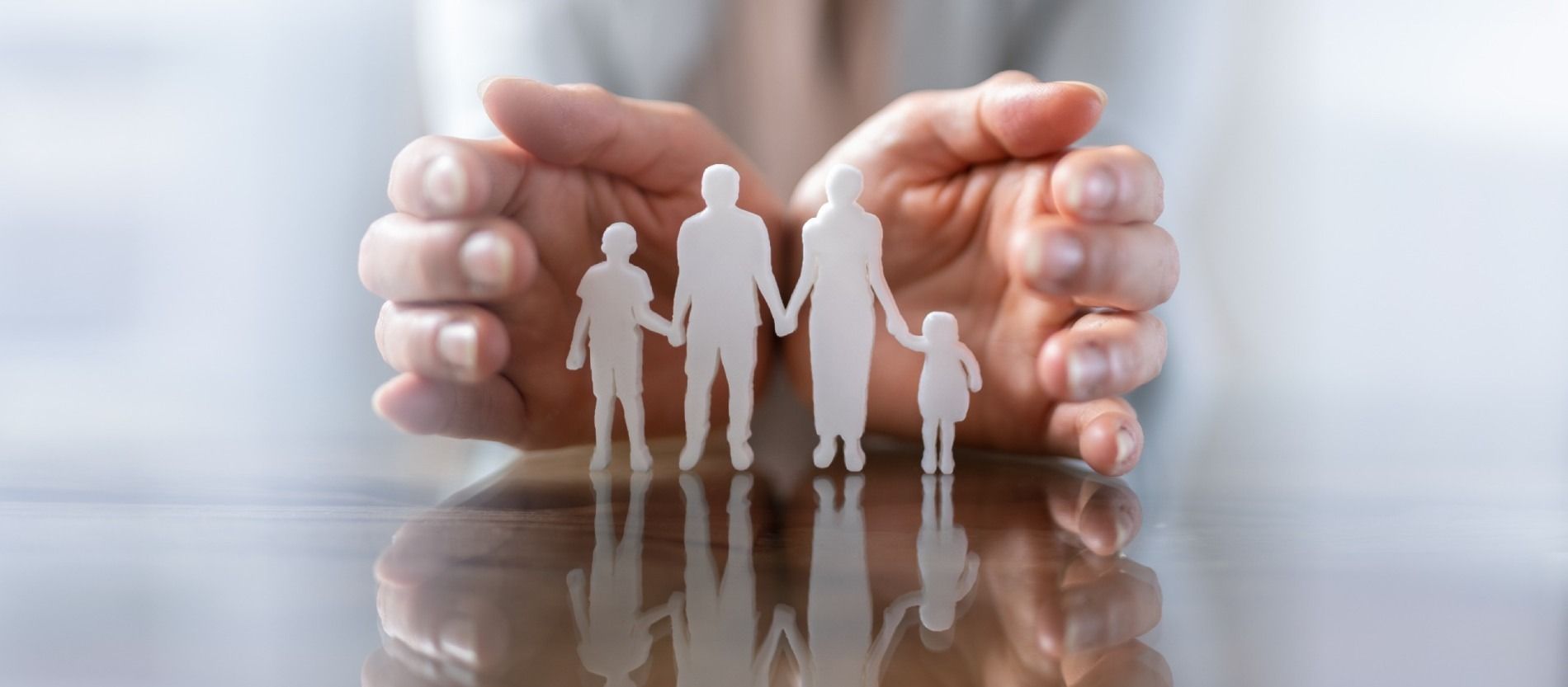 Una persona sostiene un recorte de papel de una familia.