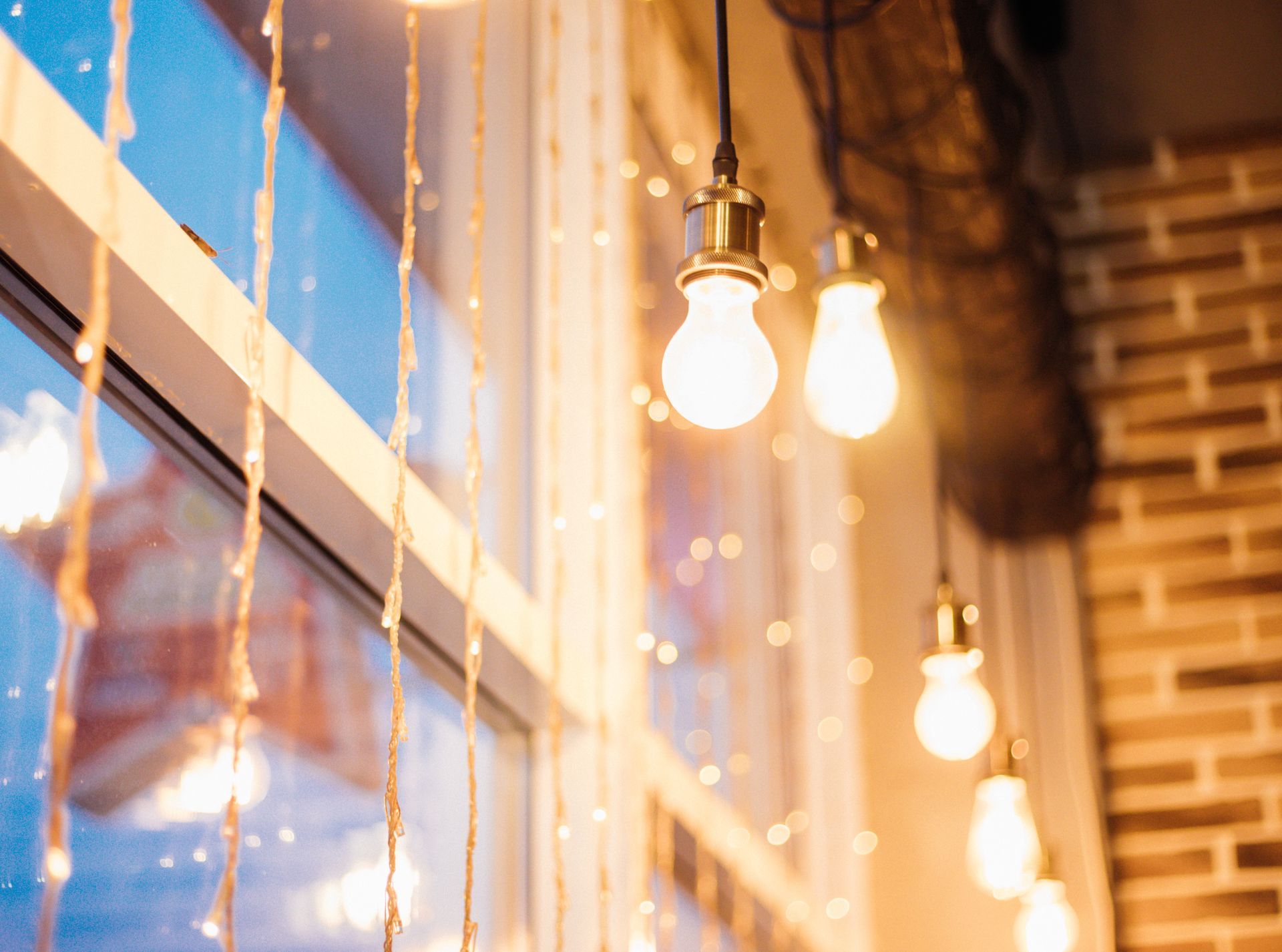 Un montón de luces colgando del techo frente a una ventana.