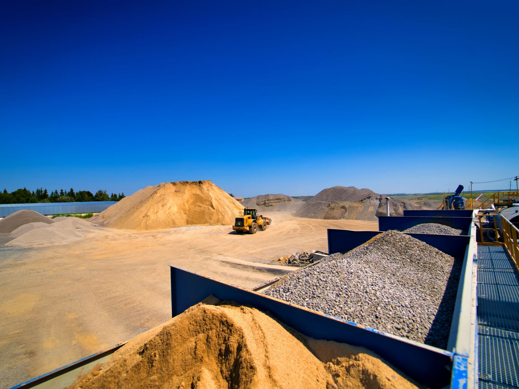 Des tas de sable et de gravier sous un ciel bleu dégagé.