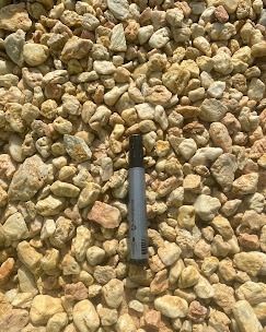 Un tas de petites pierres d'aménagement paysager arrondies, de couleur beige clair.