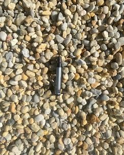 Petits galets de rivière arrondis, de couleur beige et grise.