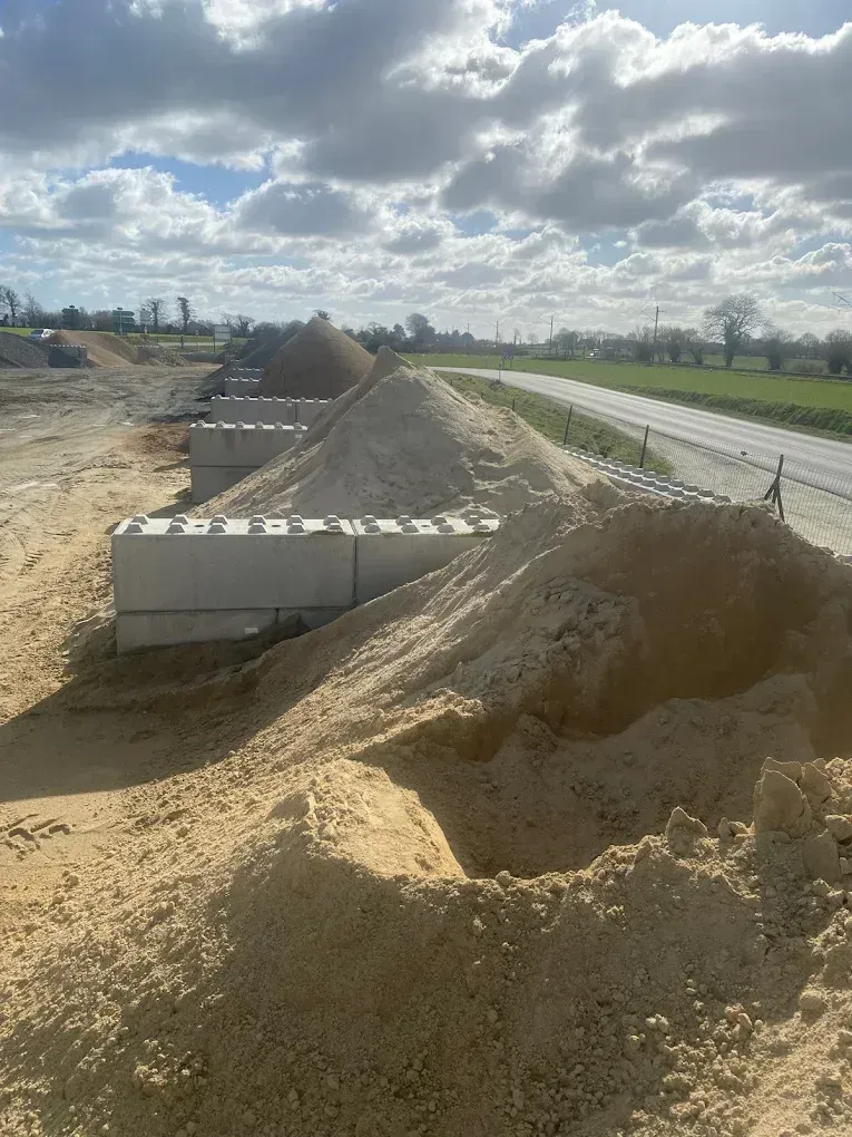 Des tas de sable et de gravier séparés par des barrières en béton.