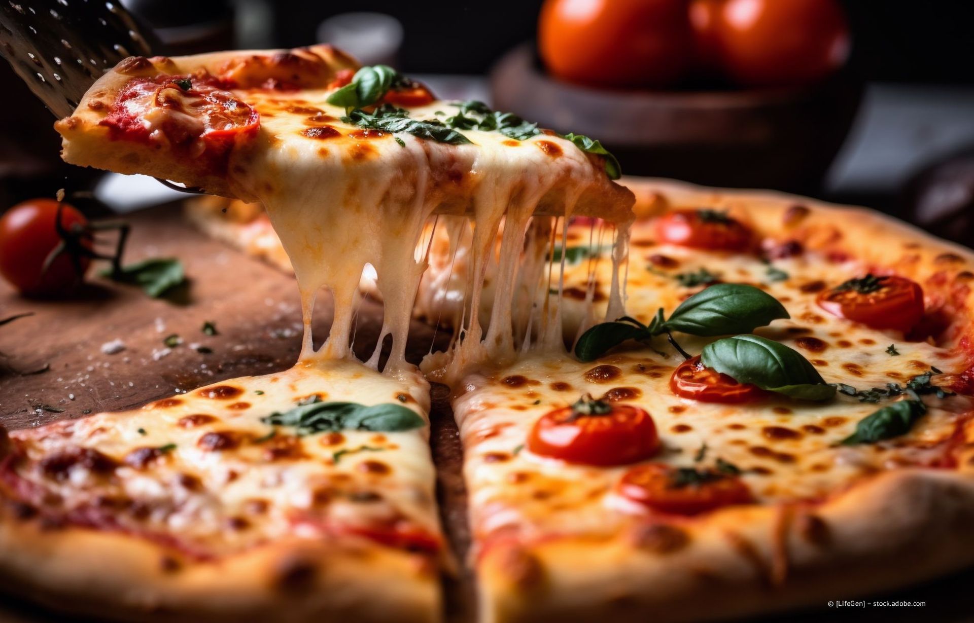 Ein Stück Peperoni-Pizza mit Käse wird angehoben, der geschmolzene Käse breitet sich auf einem Holzbrett aus.