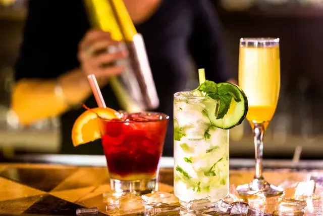 Un camarero está sirviendo una bebida en un vaso en un bar.