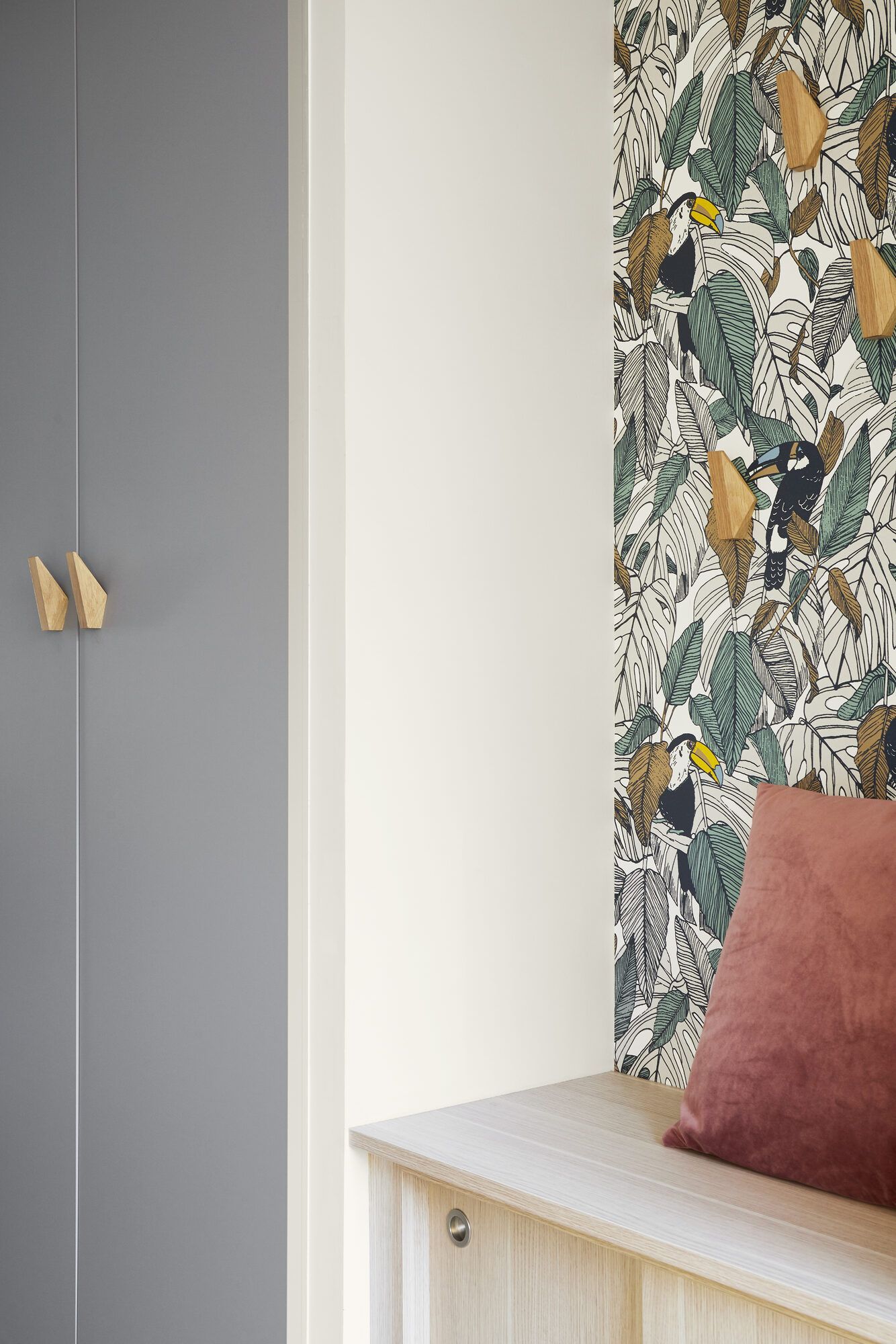 Entrée avec placard gris sur mesure, banc en bois et papier peint tropical, rénovation par Mathilde Design près de Nantes