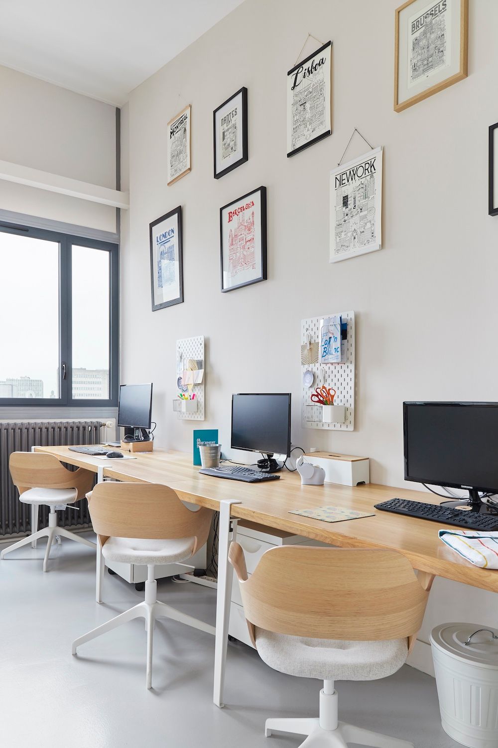Espace de travail de bureau moderne avec bureaux, ordinateurs, chaises et tableaux encadrés