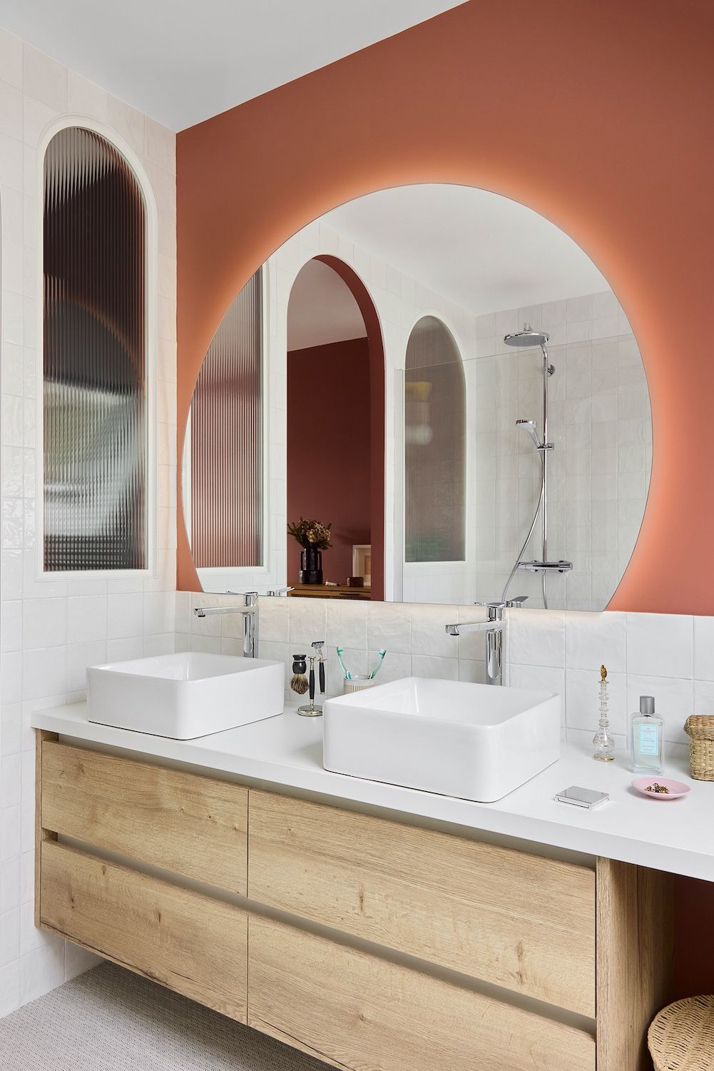 Meuble-lavabo moderne avec double vasque, miroir arqué et mur d'accent en terre cuite