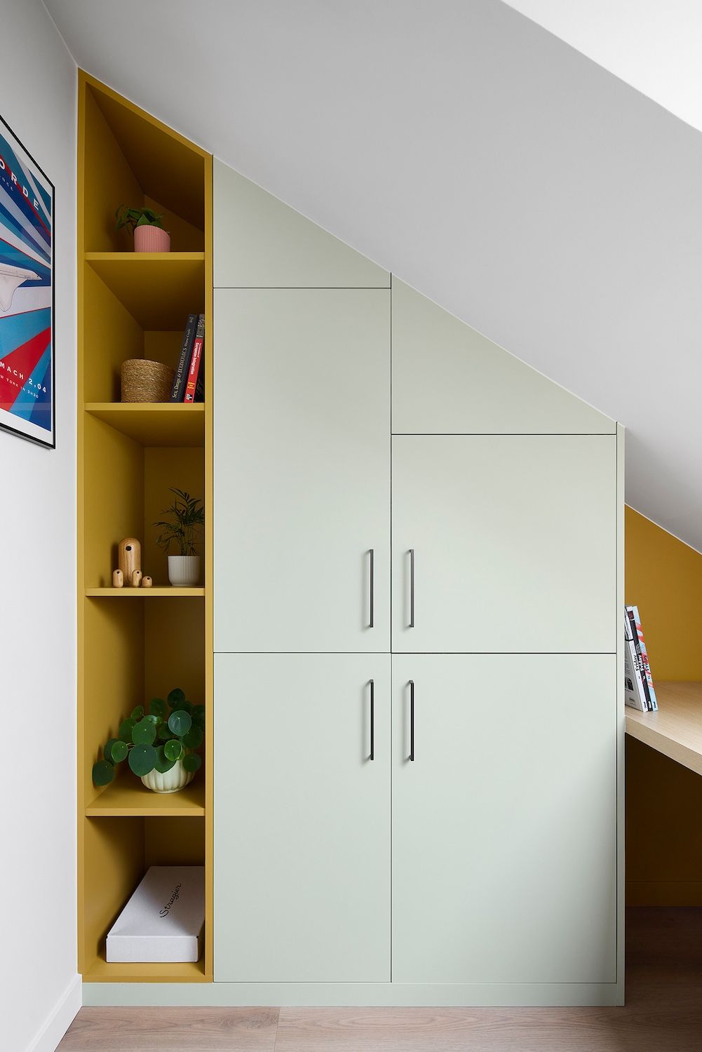 Meuble sous escalier intégré avec portes blanches et étagères ouvertes jaunes dans un intérieur de maison moderne