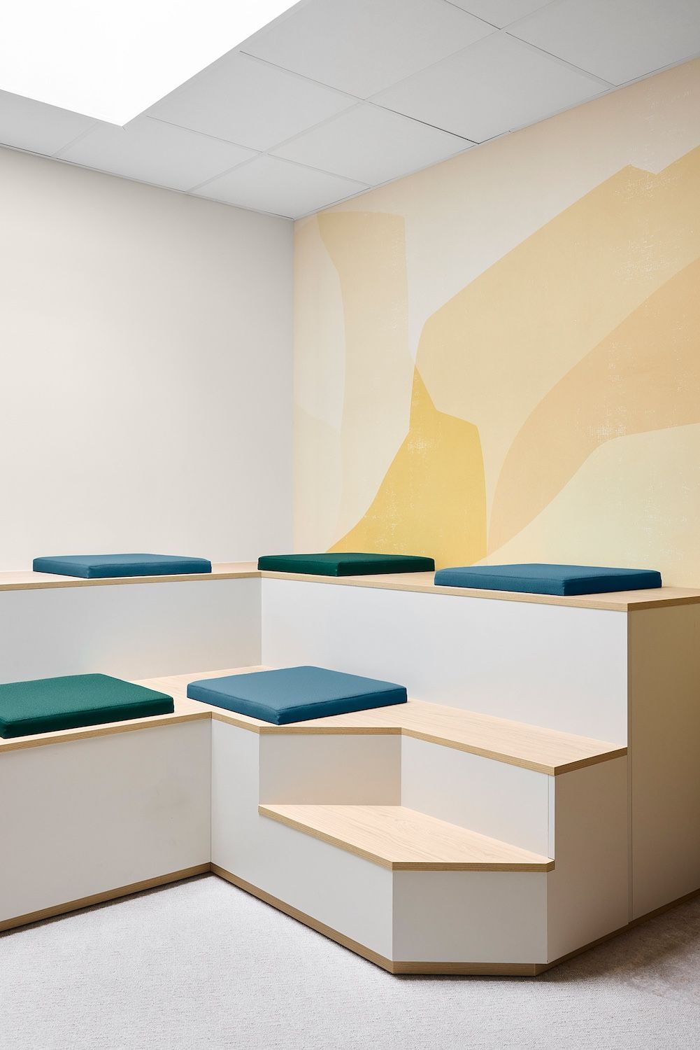 Coin salon avec banquettes blanches et coussins turquoise dans une pièce aux tons doux