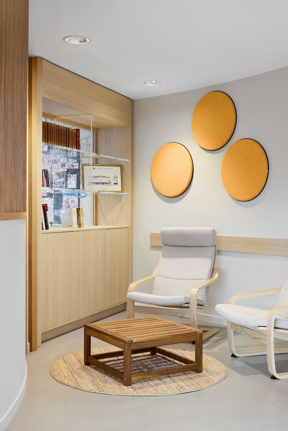 Coin bureau moderne avec bibliothèque en bois, mur végétal, banquette et grand arbre d'intérieur.