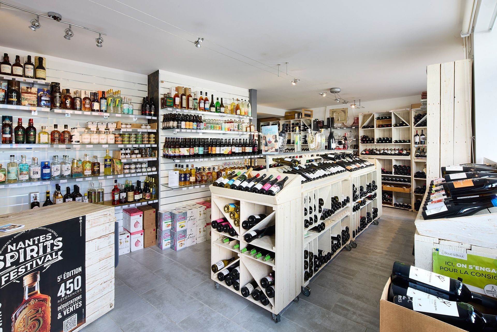 Intérieur lumineux d'un magasin de spiritueux avec des étagères de bouteilles et un comptoir d'exposition central