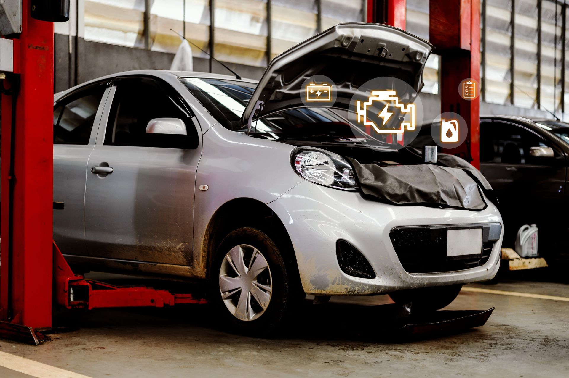 Voiture argentée soulevée par un cric hydraulique rouge dans un garage, capot ouvert pour inspection