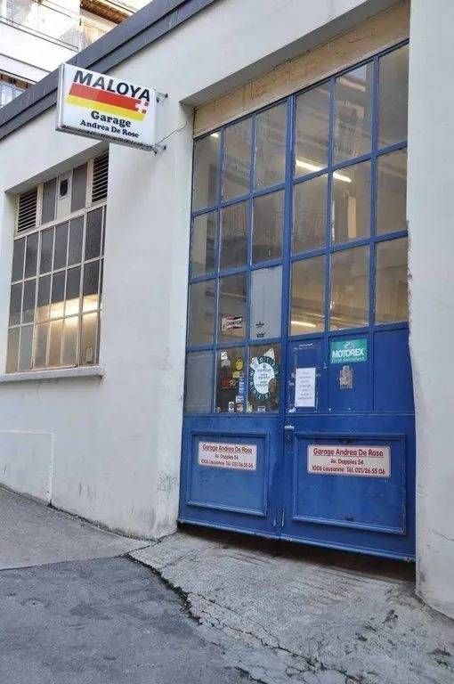 Double porte bleue sur un bâtiment blanc avec une enseigne « MAYA » au-dessus de l'entrée