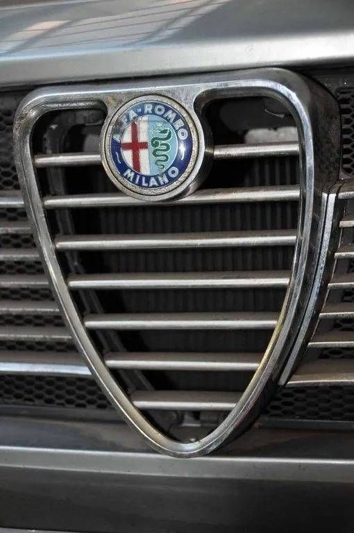 Gros plan sur la calandre d'une Alfa Romeo avec son badge et son emblème chromés.