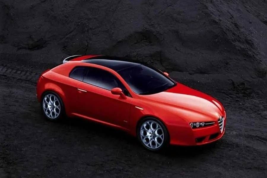 Coupé sport rouge garé sur une surface rocailleuse sombre