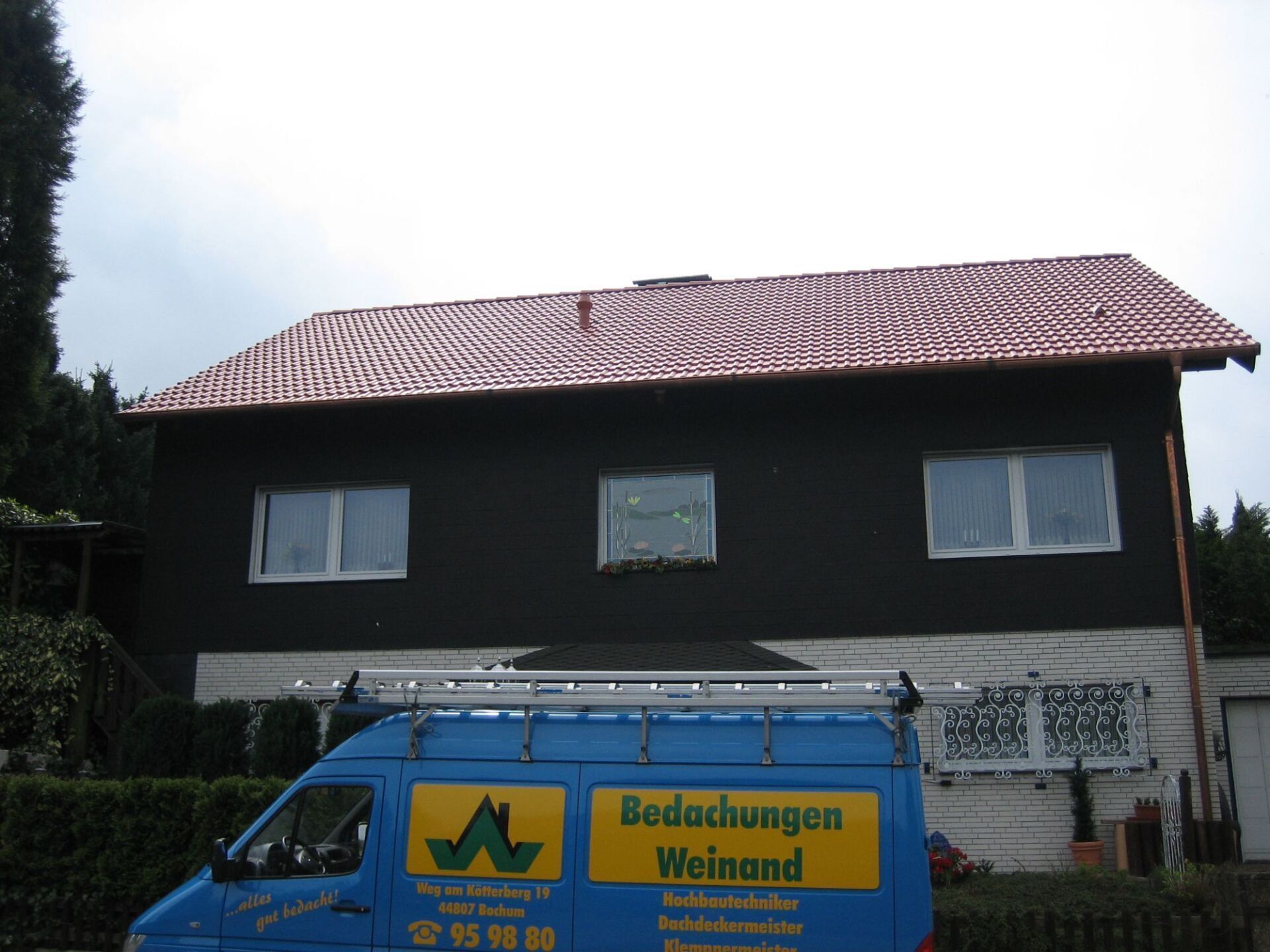 Firmenwagen Bedachungen Weinand vor Haus mit Steildach
