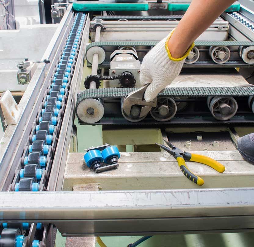 Una persona está trabajando en una máquina con un par de alicates.