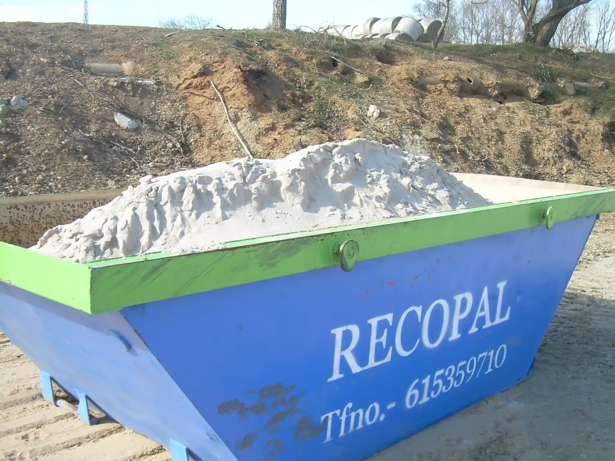 Contenedores de basura de color azul y verde en diversos entornos