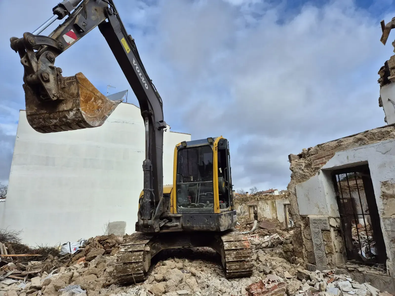 Una zanja de irrigación fangosa atraviesa un campo seco; colinas en la distancia, cielo azul en lo alto.