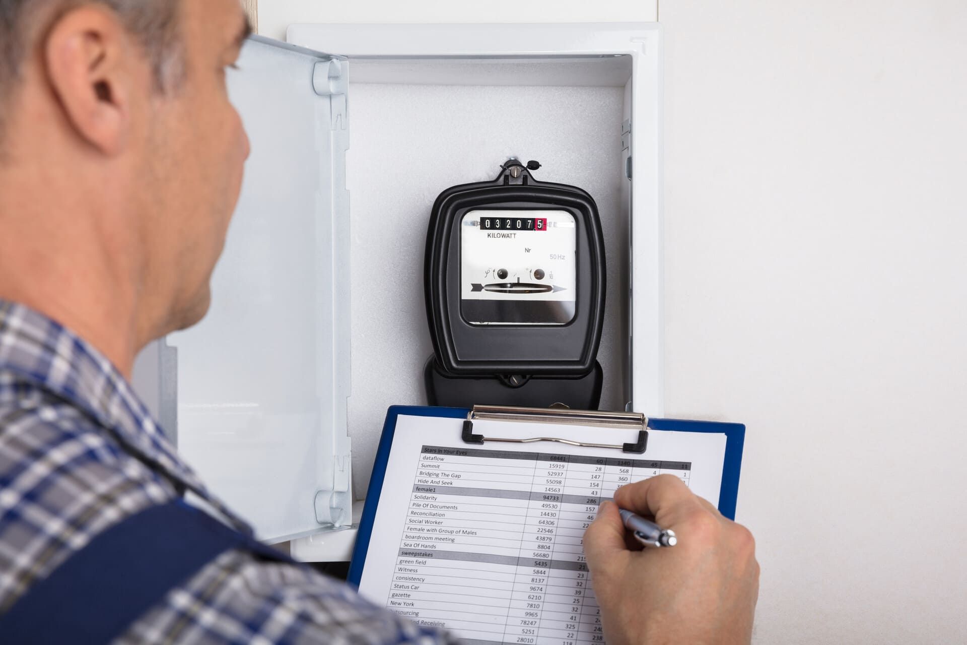 Persona quita azulejos de la pared con un martillo y una palanca.