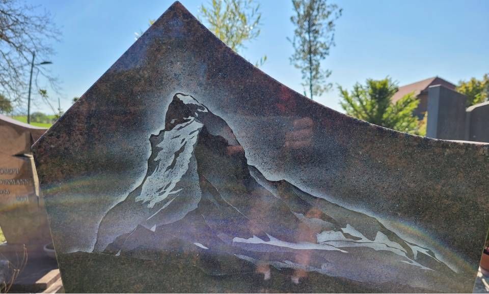 Mur de pierre endommagé avec un grand trou irrégulier et des débris devant, à l'extérieur en plein jour