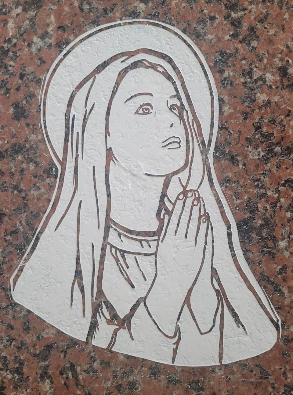 Dessin en noir et blanc d'une figure en prière, les mains jointes, sur fond de granit.