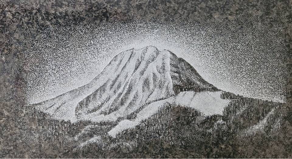 Montagne enneigée au sommet rocheux sombre, entourée de brume ou de nuages