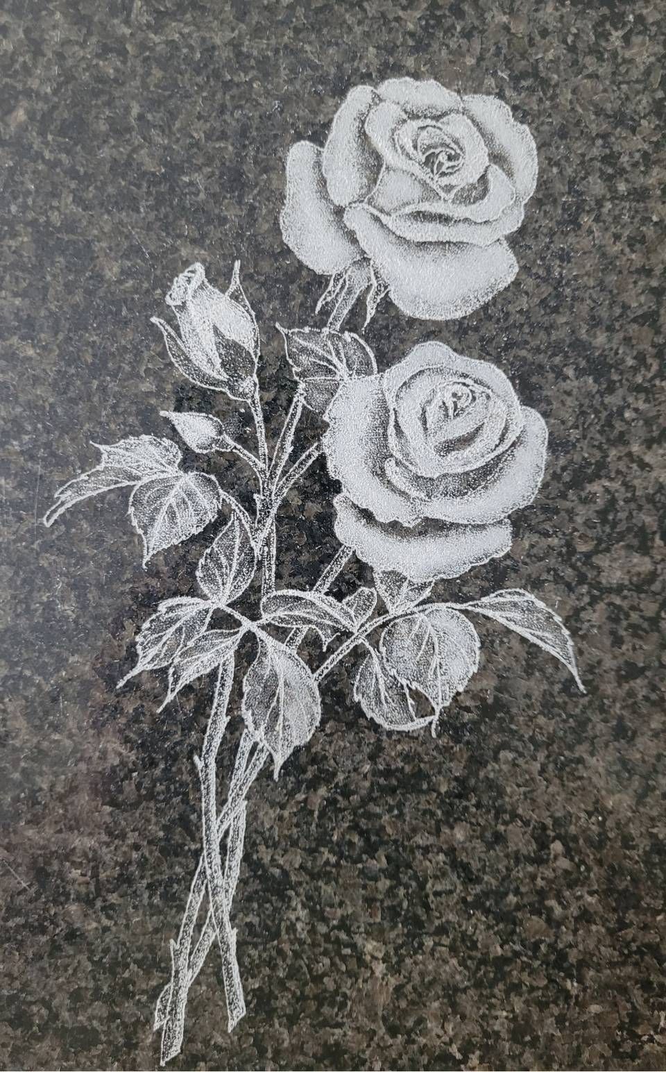 Broderie de roses blanches sur fond sombre imitant la pierre