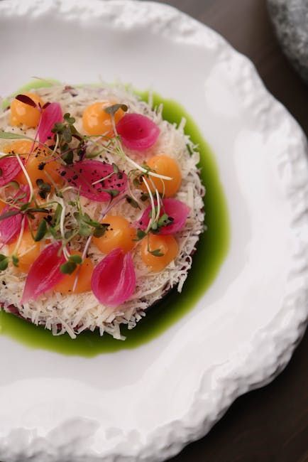 Plato gourmet con comida colorida. Salsa verde, bolitas de melón, cebollas rosadas encurtidas, microvegetales y queso blanco rallado.