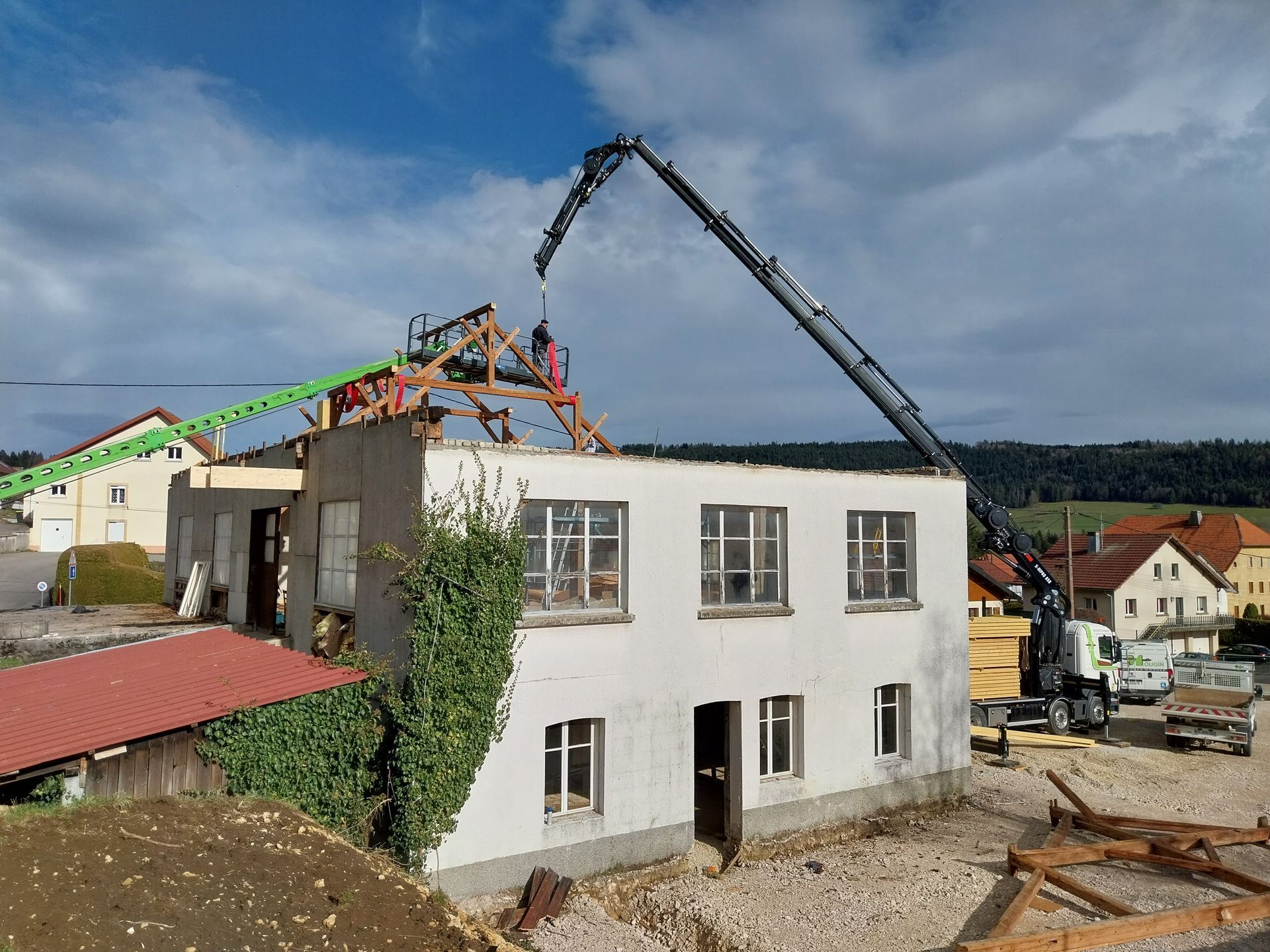 Démolition d'un bâtiment à l'aide d'une grue pour retirer le toit.