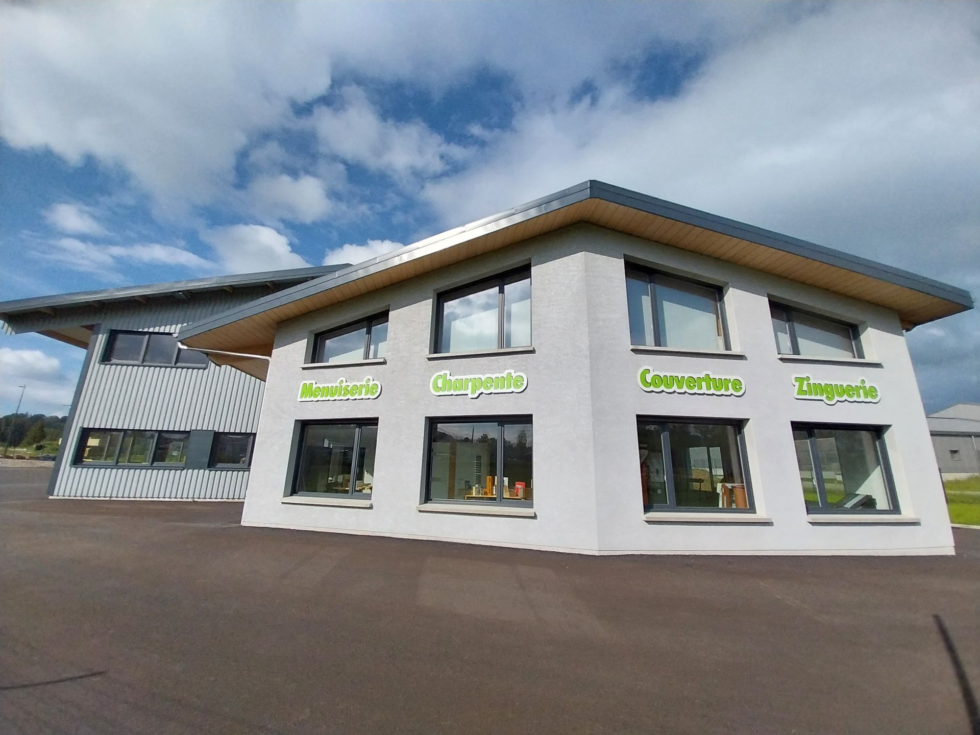 Bâtiment blanc de deux étages avec une signalétique verte, portant les inscriptions Blumen-Loris, Champagne, Loungestone et Dagsteria sur les fenêtres.