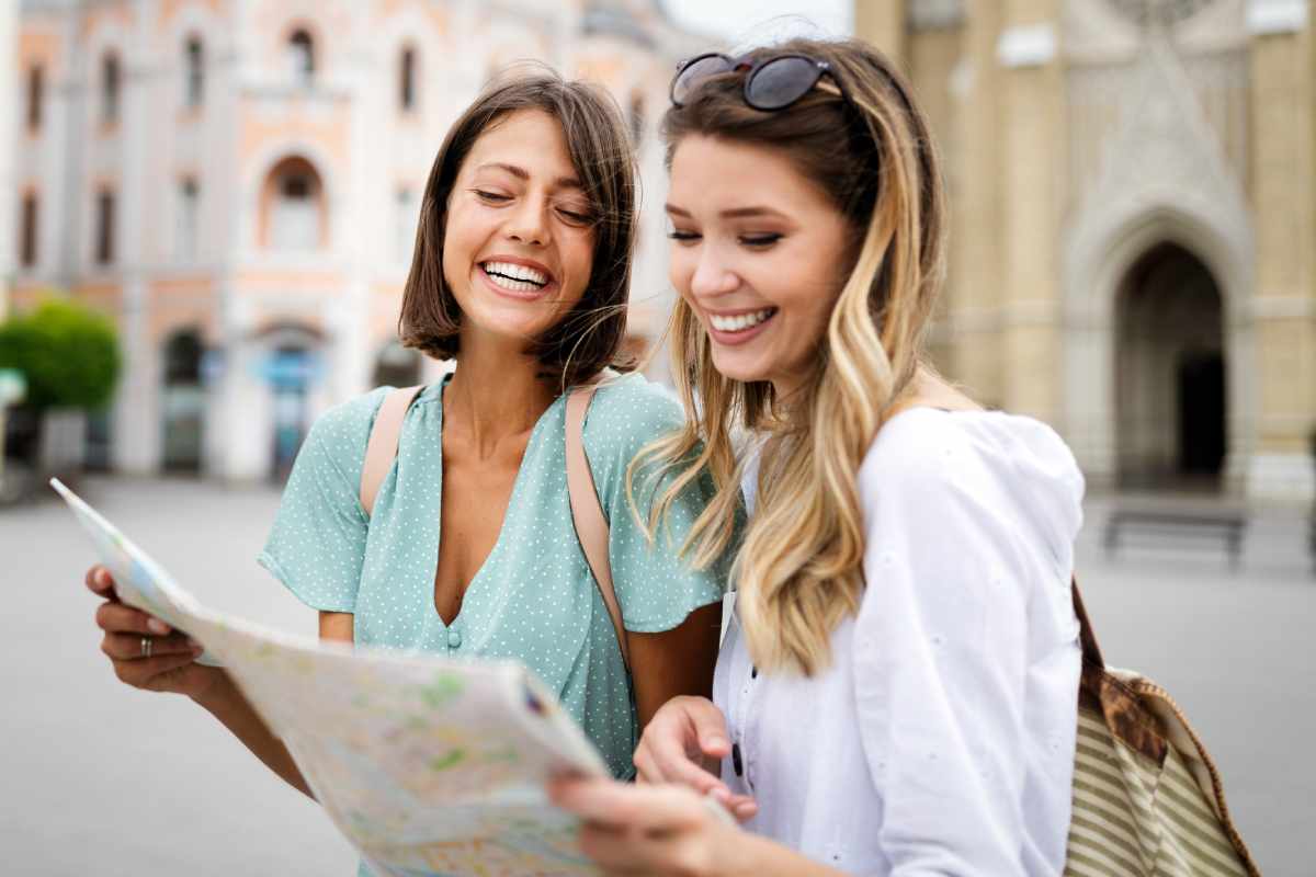 Two women are looking at a map together in a city.