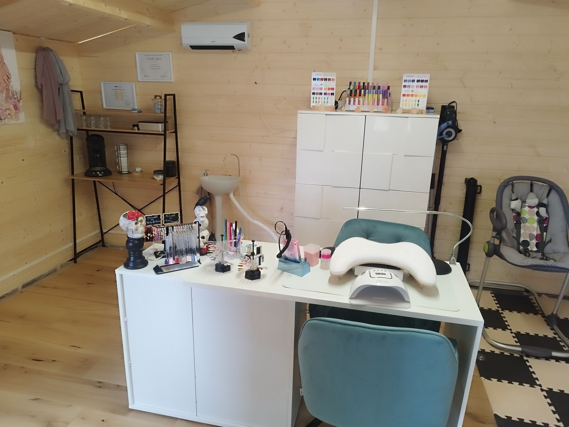 Intérieur de salon de manucure : bureau blanc avec fournitures de manucure, armoire blanche, étagère et chaise bébé.
