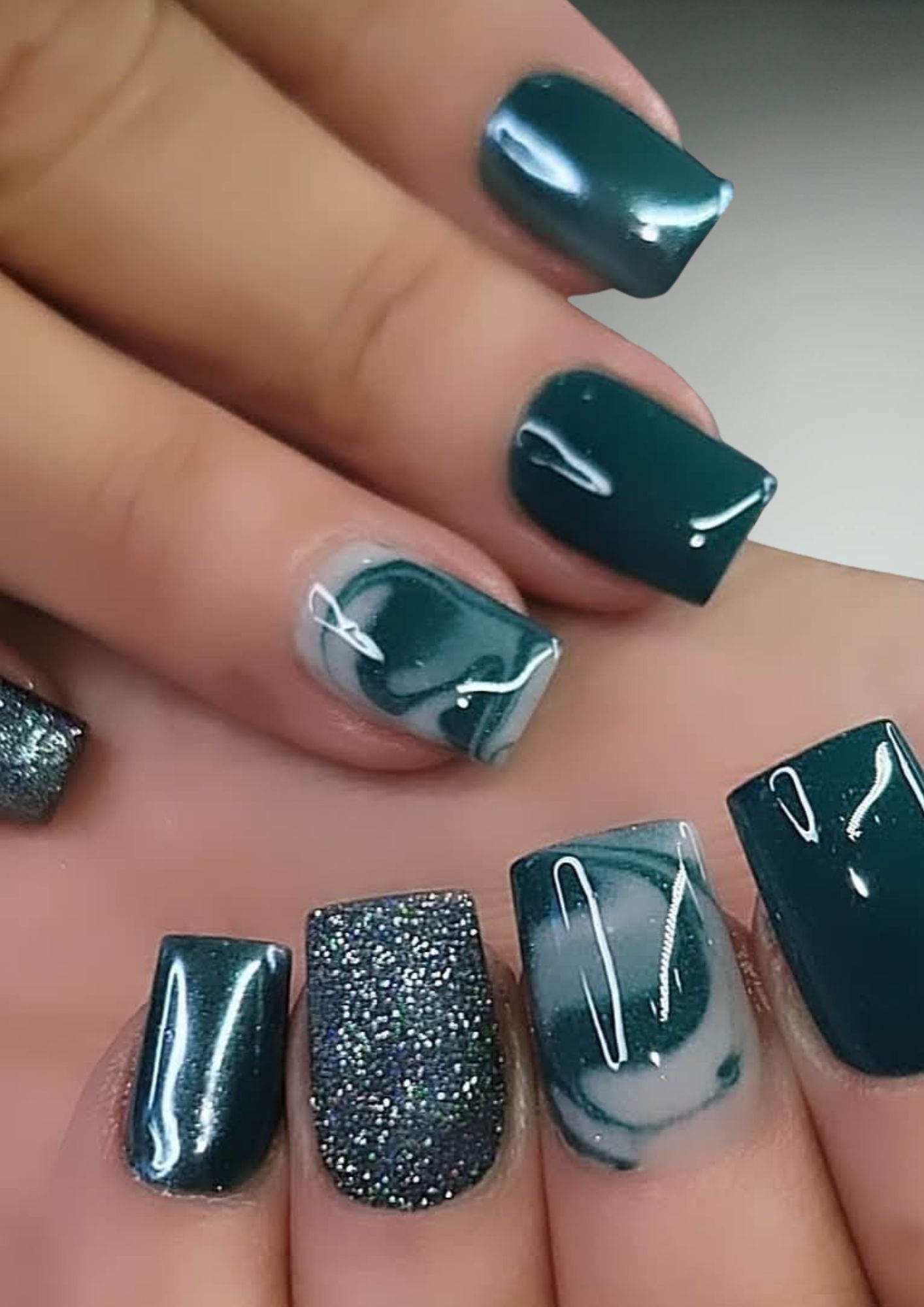 Main avec du vernis à ongles marron et deux ongles à motifs comportant des rayures noires, blanches et jaunes.