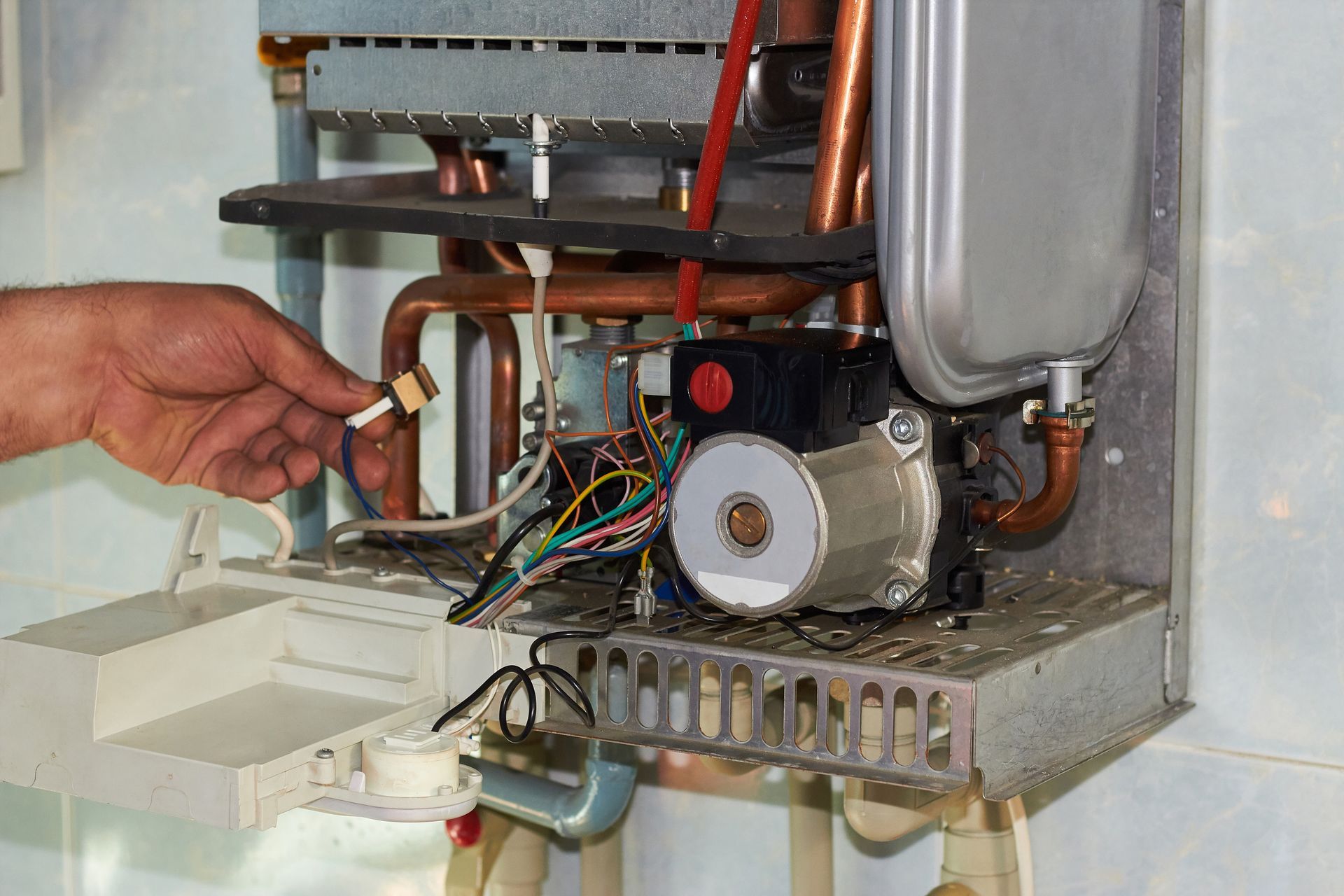Réglage manuel du câblage à l'intérieur d'un appareil métallique ouvert avec moteur et tuyauterie apparents